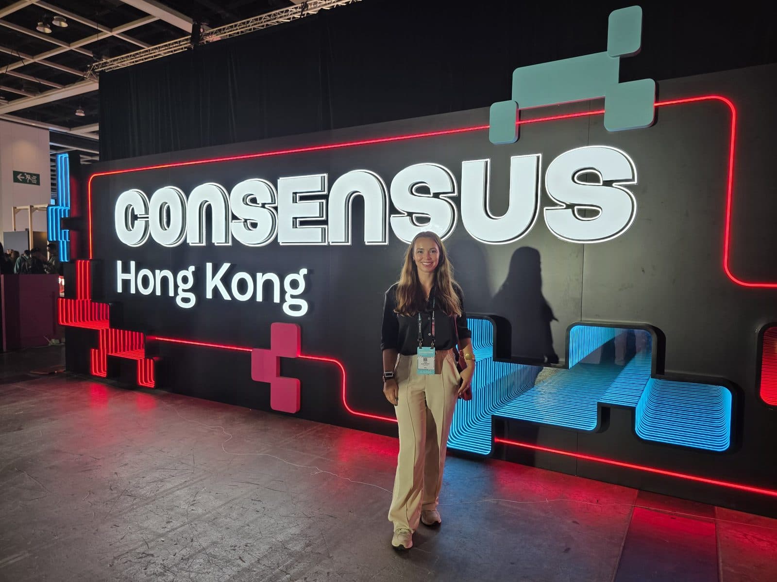 Lucy at Consensus Hong Kong, standing in front of the illuminated conference sign