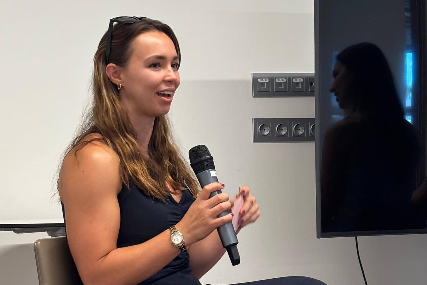 Lucy speaking on a panel, holding a microphone